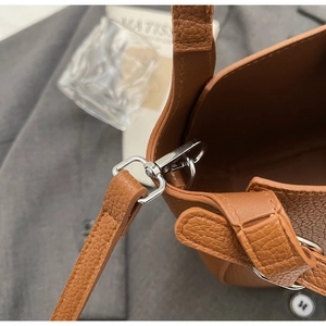 Detail einer braunen Kieselleder-Handtasche mit Silberschnalle und sauberen Nähten