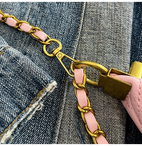Détail de sac matelassé rose avec bandoulière en chaîne et crochet doré brillant