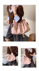 Detailed side view of pink pleated tote bag with drawstring and star charm decoration
