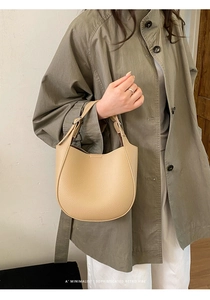 Detail of beige litchi texture PU leather hobo bag with wide handle and minimalist design