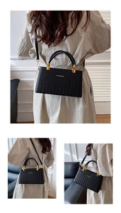 Detail showing black woven texture handbag with gold lettering and detachable shoulder strap