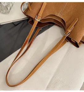 Detail of adjustable strap with contrast stitching on a vintage brown leather tote bag