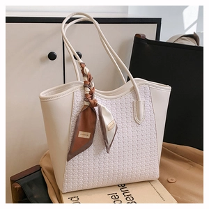 Close-up of cream woven tote bag with premium PU leather and decorative fashion scarf