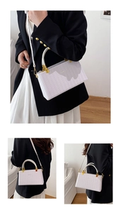 Detail view of woven pattern on purple crossbody bag with leather handle and gold hardware