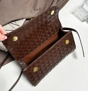Dettaglio dell'interno di borsa in pelle intrecciata marrone con chiusura magnetica