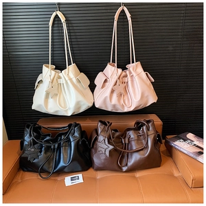 Detailed view of four colorful drawstring bucket bags with star charms and soft textures