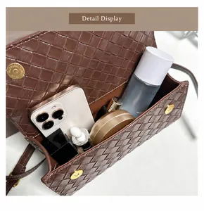 Vista interna della borsa in pelle intrecciata marrone con spazio per telefono e cosmetici
