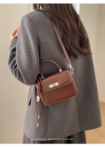 Brown retro crossbody bag shown on a model in a gray suit for a chic urban look