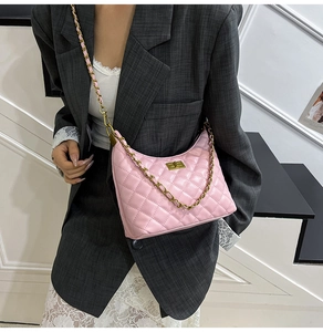 Sac demi-lune rose matelassé avec chaîne dorée porté par un mannequin