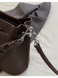 Vue macro du crochet en métal argenté et du cuir à grain de litchi sur le sac marron