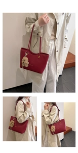 Detail of wine red leather tote bag with gold lettering and cute bear charm accessory