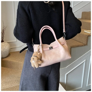 Pink bucket bag with silver clasp and cute puppy charm shown from a back perspective