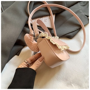 Vue détaillée du mini sac à bandoulière rose avec bordure dentelle et charme cœur