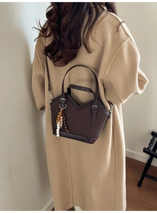 Détail du sac seau plissé marron foncé sur mannequin avec breloque rétro en perles