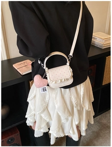 Détail du petit sac à bandoulière à pois avec bordure en dentelle et cœur rose