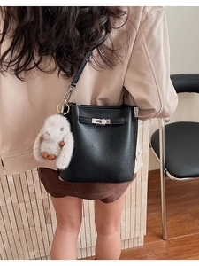 Détail du sac seau en cuir noir avec fermoir tournant argenté et breloque lapin en peluche