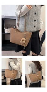 Detail of brown leather tote bag with gold lettering and cute bear plush charm