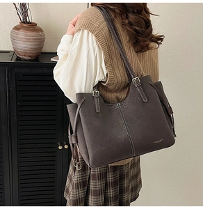 Close-up of large tote bag with contrast stitching and matte texture in a cozy setting