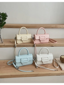Chic mini handbags in pastel yellow, pink, blue, and white on a wooden display