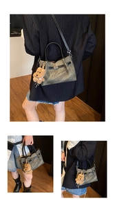 Detail of retro bucket bag in vintage canvas with leather handles and bear charm