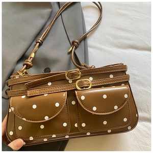 Détail du sac bandoulière vintage marron avec pois blancs et boucles dorées élégantes