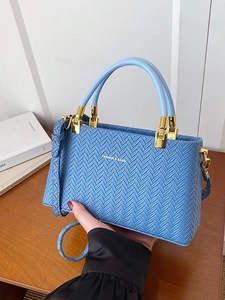 Minimalist light blue woven textured handbag with gold hardware and top handle strap