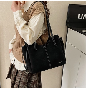 Close-up of large black tote bag featuring distinctive white contrast stitching detail