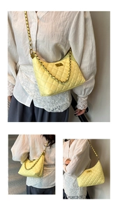 Détail du sac bandoulière matelassé jaune avec chaîne dorée et fermoir pivotant sur modèle