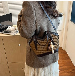 Détail du sac seau plissé vintage avec breloque ethnique en perles et base contrastée