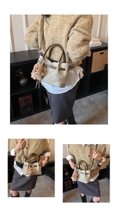 Detail of beige bucket bag with brown leather straps and cute plush bear charm accessory