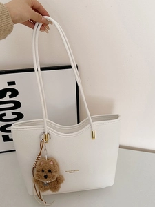White faux leather tote bag with lychee texture and brown puppy plush charm