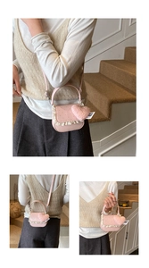 Détail d'un petit sac rose avec bordure en dentelle blanche et pendentif coeur peluche