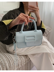 Detail of light blue leather handbag with square buckle and woven knot accent