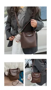 Vue détaillée du sac seau en cuir grainé marron avec fermoir rotatif et breloque lapin