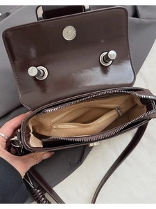Detail of deep brown retro crossbody bag showing inner compartment and zipper pocket
