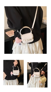 Détail du mini sac à pois avec bordure en dentelle et pendentif cœur rose