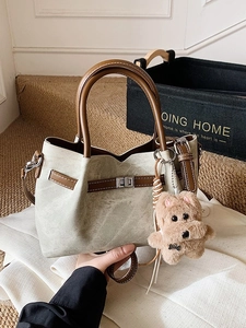 Vintage green bucket bag with brown handles and a cute puppy plush charm for women