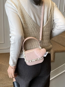 Sac bandoulière rose à pois avec bords en dentelle et breloque cœur sur mannequin
