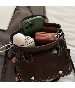 Spacious interior of a brown pebble leather crossbody bag with white stitching detail