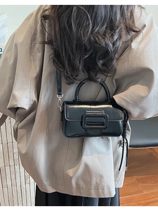 Model view of black shiny rectangular crossbody bag with decorative large square buckle