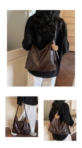 Detail of large brown faux leather tote bag with rivets and decorative plush bear charm