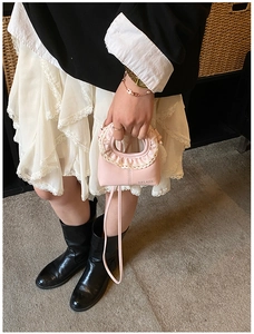 Détail du sac à main en cuir PU rose avec dentelle crème et logo Helahe imprimé