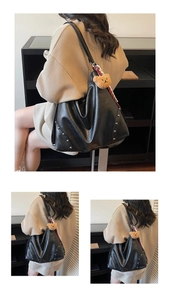 Detail of black leather tote bag featuring silver studs and a plush bear charm accessory