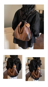 Detail of retro brown leather hobo bag featuring rivet accents and a plush bear charm