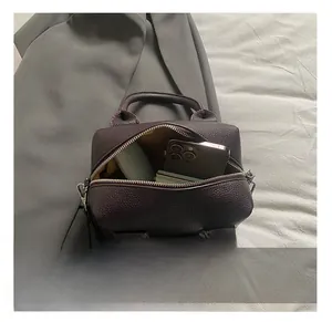 Macro shot showing the spacious interior and smartphone inside this dark brown Boston bag