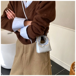 Détail du mini sac à rouge à lèvres bleu clair avec dentelle et logo HECARE sur le sac