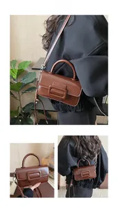 Detail view of caramel brown leather handbag showing top handle and adjustable shoulder strap