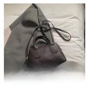 Close-up of coffee brown lychee leather texture on a stylish baguette handbag