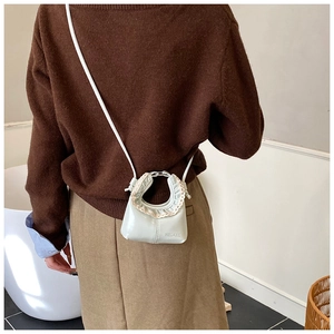 Mini sac bandoulière à volants vert clair HELAHE porté par un mannequin en maille