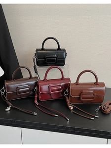 Detail view of four square crossbody bags in black, dark brown, red, and tan leather